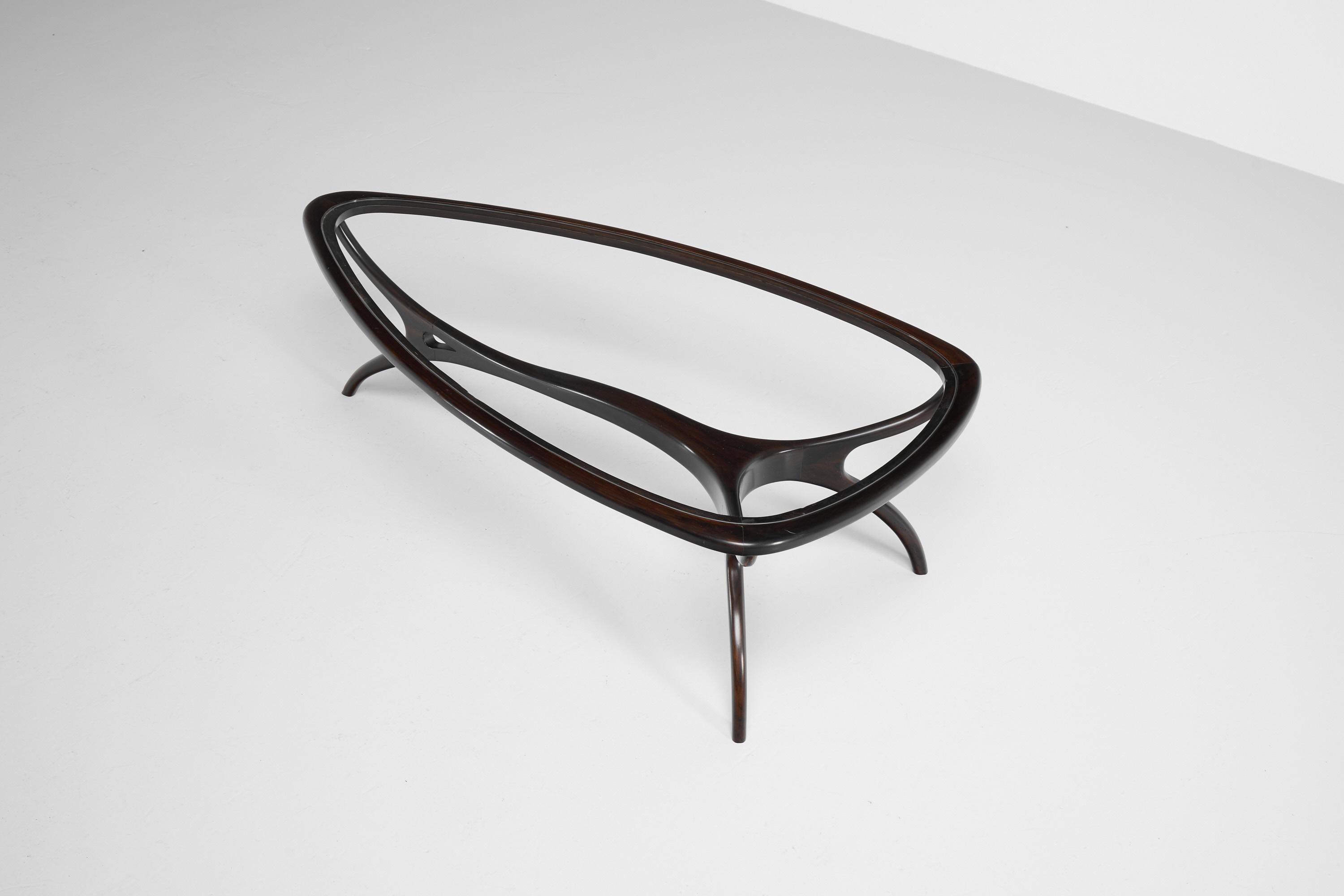 Striking coffee table designed by Giuseppe Scapinelli and manufactured in his workshop in Brazil, 1950. This sculptural shaped coffee table is made of very dark and deep coloured rosewood. It has a somewhat oval shape and 3 very elegant shaped legs.