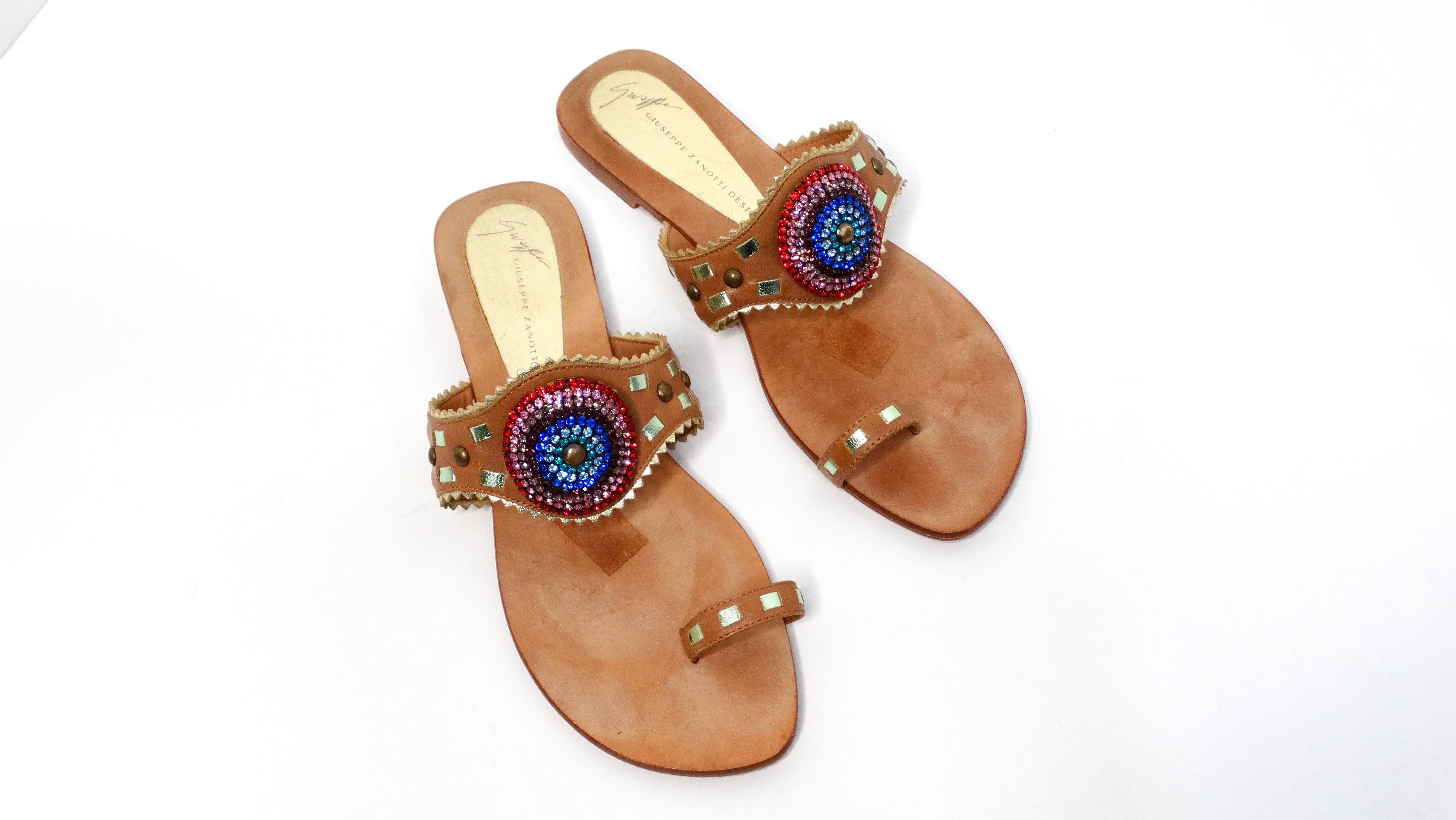 Peppen Sie Ihre Sommergarderobe mit den exquisiten Giuseppe Zanotti Sandalen aus braunem Leder mit Regenbogenstrass auf. Diese luxuriösen Flip-Flops verfügen über ein sorgfältig gefertigtes Band, das mit einem atemberaubenden, kreisförmigen