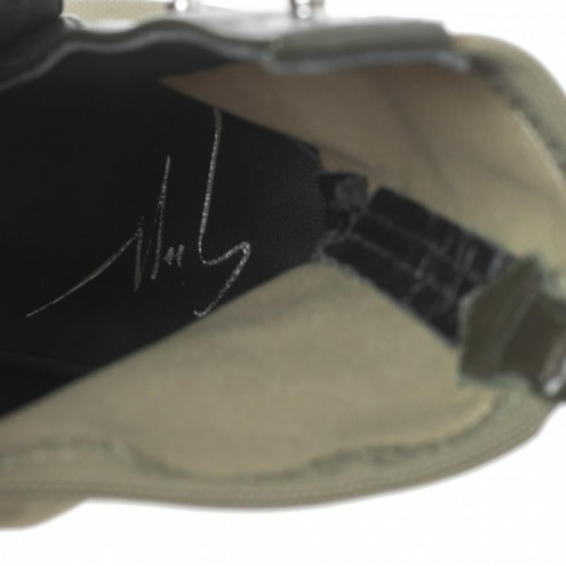 Ces bottes Giuseppe Zanotti, qui montent jusqu'à la cheville, affichent un style militaire chic. Cette paire à bouts pointus, réalisée en toile et cuir vert armée, est dotée de boutons-pression argentés polis qui remontent sur les côtés. Elles sont
