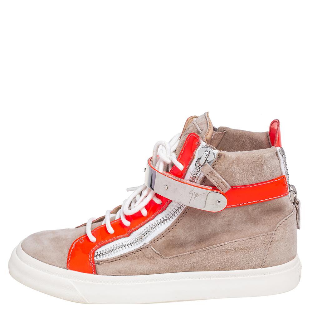 Bring home the luxurious high-fashion touch with these sneakers from Giuseppe Zanotti. Crafted from neon orange patent leather and beige suede, these sneakers come flaunting luxe details like the velcro straps, the lace-ups, and the zippers on the