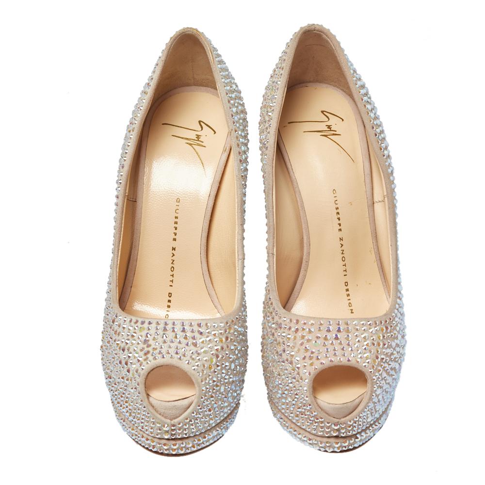 Add a sparkling touch to your outfit when you wear these Giuseppe Zanotti pumps. Crafted from beige suede, they are densely covered with dazzling crystals throughout. Elevated on 14 cm towering heels, these pumps are supported by