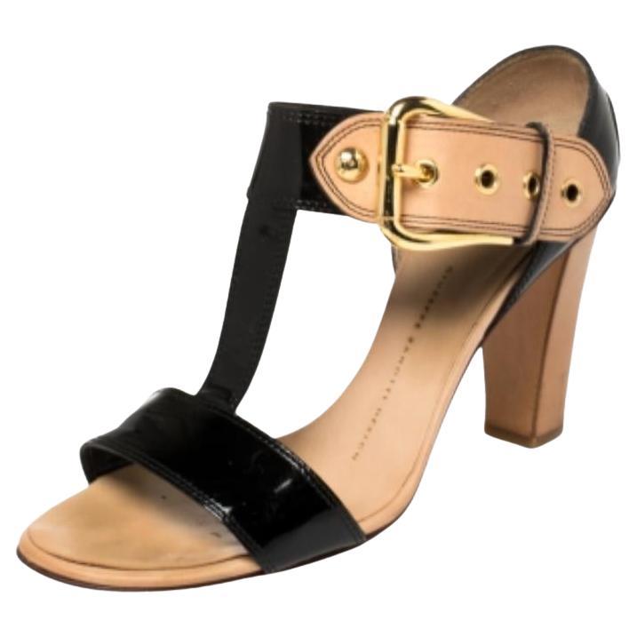 Contemporary and sleek, Giuseppe Zanotti's sandals exude Italian craftsmanship in shoemaking. Crafted from patent leather, they feature open toes, t-straps adjoining the broad buckled straps. The sandals have been set on block heels so that you can
