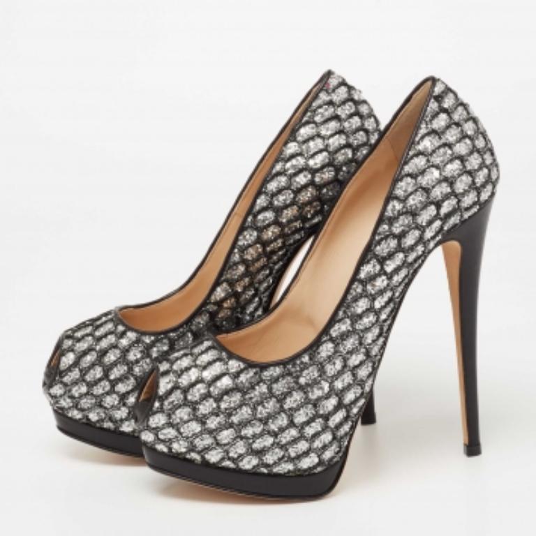 Con una impresionante silueta realzada con excelencia, estos zapatos de Gianvito Rossi sólo desprenden estilo y brillo. Están diseñadas con purpurina negra y encaje en el exterior. Estos zapatos de salón presentan peep toes, tacones finos,