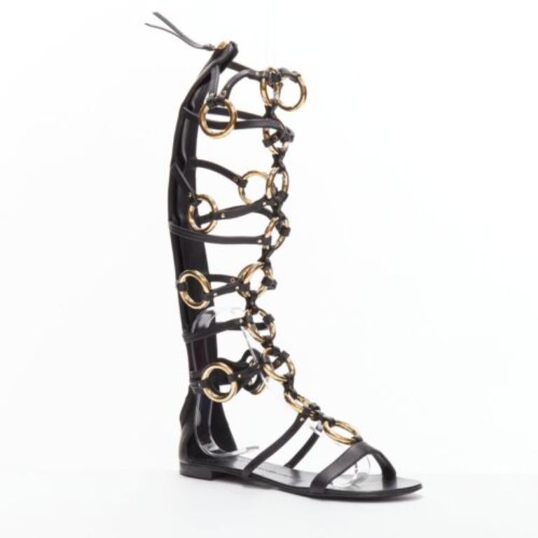 GIUSEPPE ZANOTTI black gold ring bondage gladiator sandal EU38.5
Reference: BSHW/A00149
Brand: Giuseppe Zanotti
Material: Leather, Metal
Color: Black, Gold
Pattern: Solid
Closure: Zip
Lining: Black Leather
Extra Details: These gold-toned leather