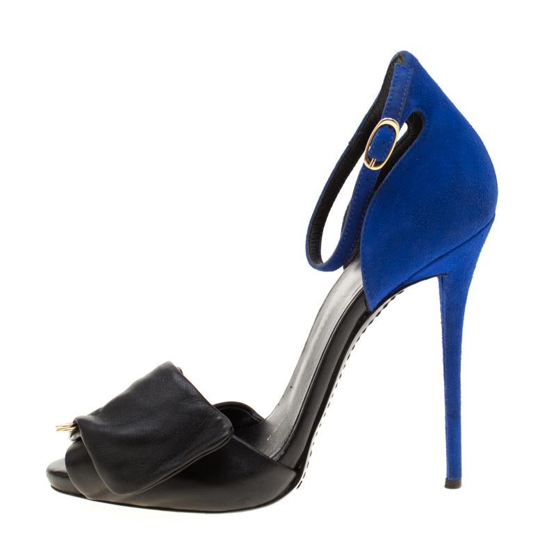 Now make the streets your fashion runway in these stunning Giuseppe Zanotti sandals! The black and blue beauties are crafted from leather and suede, and feature a peep-toe silhouette. They are artistically styled with a gold-tone safety pin on the
