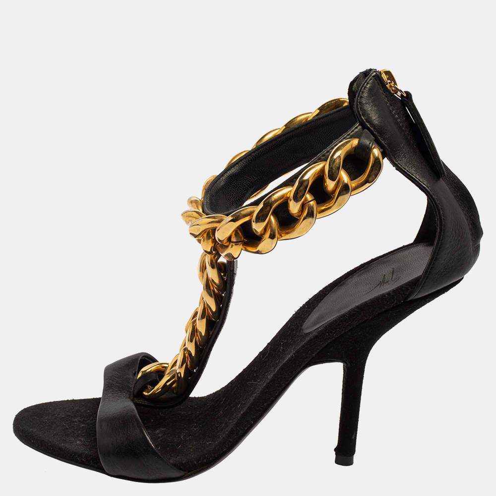 This classic pair of T-strap sandals are made exclusively for those special occasions. The bold black leather and the stunning gold-tone chain detail on the T-strap give it an impressive look. What's more? This is a Giuseppe Zanotti creation, a