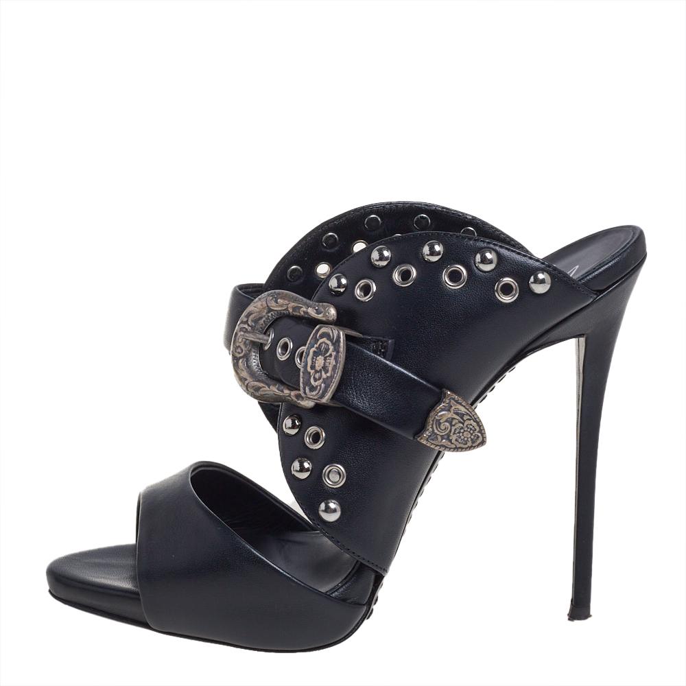 Diese Pantoletten von Giuseppe Zanotti haben uns sehr beeindruckt! Sie sind aus schwarzem Leder in einer offenen Zehensilhouette gefertigt und mit auffälligen Schnallen-, Ösen- und Nieten-Details versehen. Bequeme, ledergefütterte Innensohlen und 13