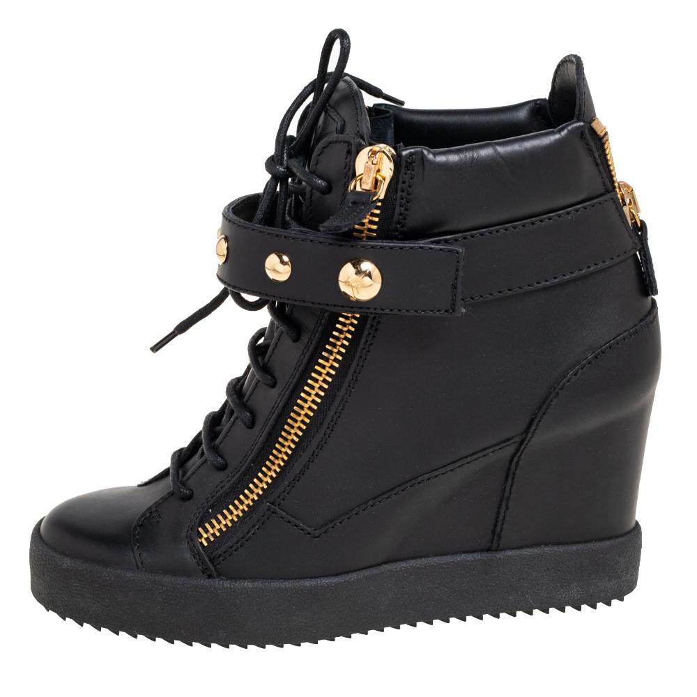Classy, chic, and charming, these sneakers designed by the House of Giuseppe Zanotti are an absolutely delightful pair you'll love to wear! They are crafted using black leather, which is enhanced with gold-tone decorative details. Their vamps come
