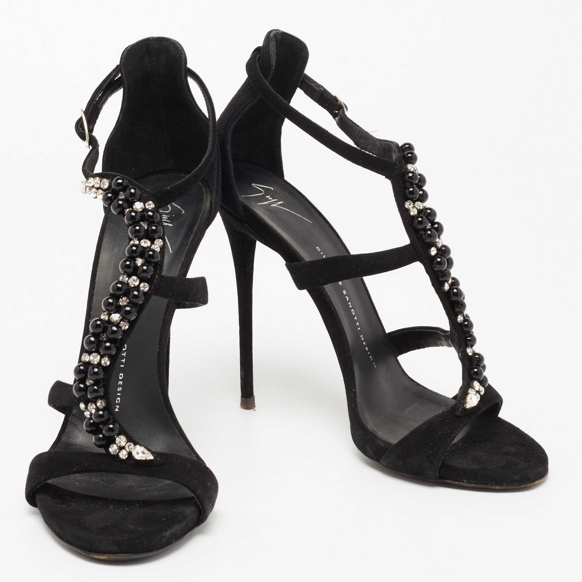 These sandals from Giuseppe Zanotti will lend a stylish and glamorous edge to your feet. This beautiful pair of suede sandals carries a classic shade of black. It has crystal-embellished T-straps, buckled closures, and 13 cm heels. The sandals are