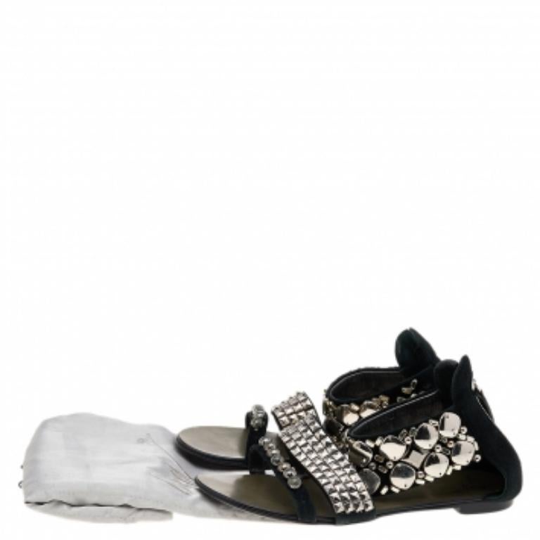 Ces sandales signées Giuseppe Zanotti présentent un design en daim noir et une quincaillerie argentée. Ils sont ornés de clous métalliques sur toute leur surface, d'orteils ouverts et de fermetures à glissière sur les contreforts. Vous êtes sûre de