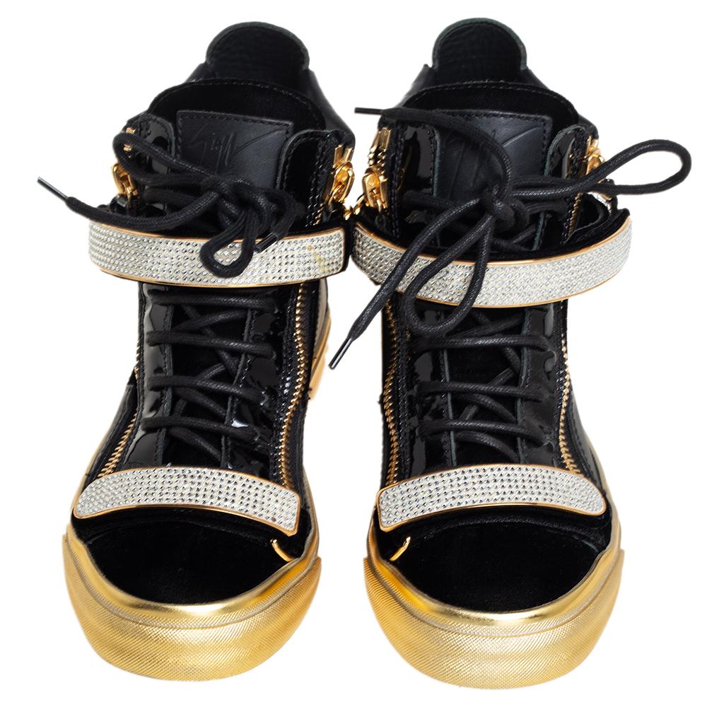 These high-top sneakers from Giuseppe Zanotti are astoundingly beautiful. They have been crafted from black leather & velvet and detailed with crystal-embellished velcro straps, double zippers on the sides, lace-ups on the vamps, brand logos on the