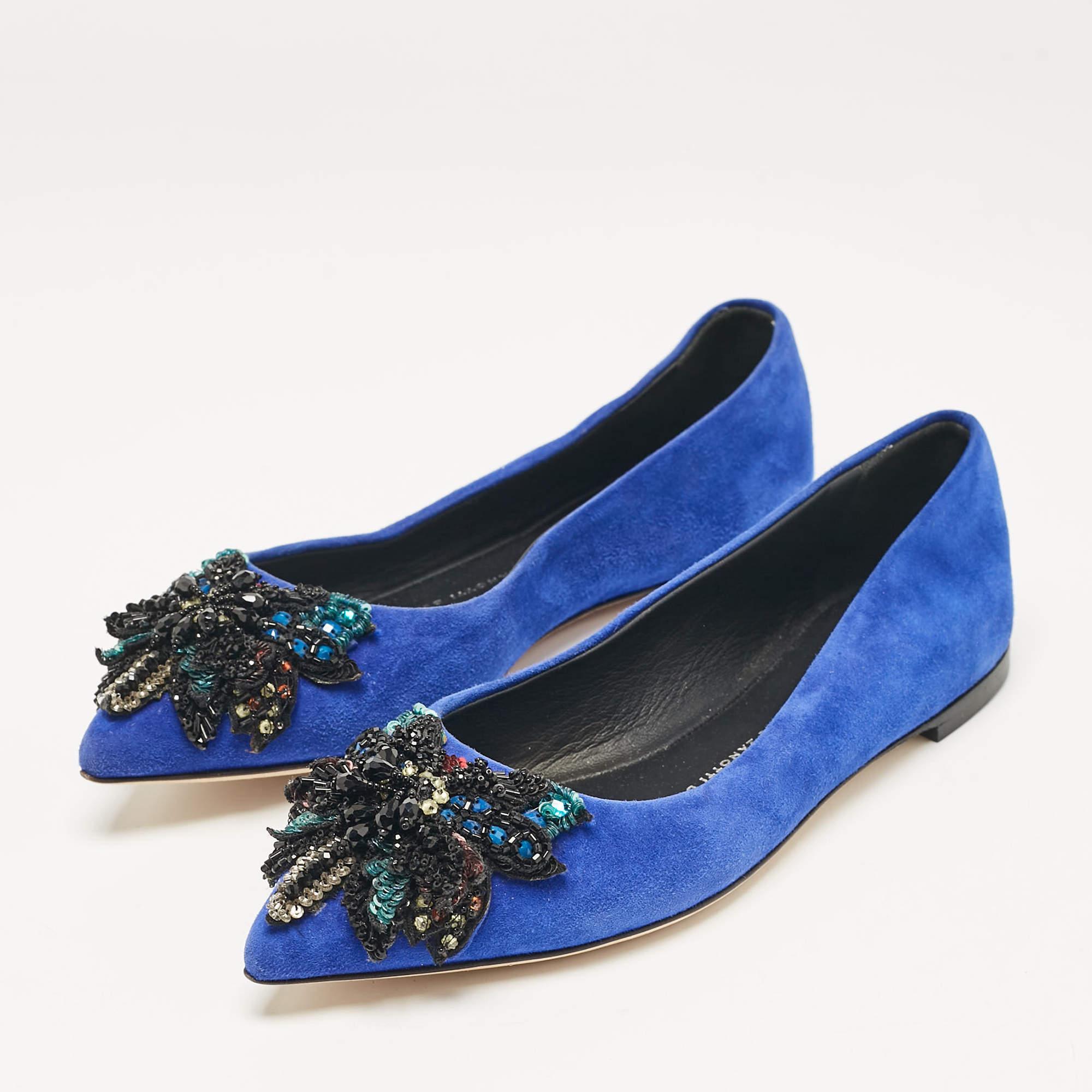 Ces ballerines bleues sont fabriquées en daim et présentent des orteils pointus ainsi que des ornements en cristal sur le dessus. Des semelles intérieures confortables, doublées de cuir, complètent cette superbe paire. Associez ces chaussures plates