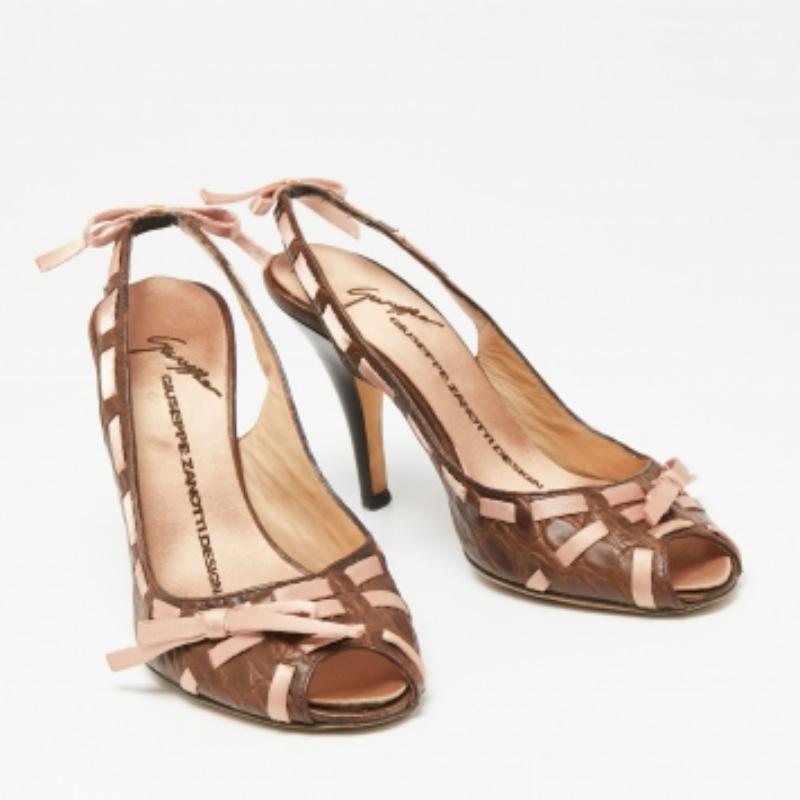 The bow detailing on the front and back of these Giuseppe Zanotti sandals adds to their overall appearance. Made from croc-embossed leather, they are characterized by peep toes, a slingback closure, and satin insoles. The 9cm heels of this pair will