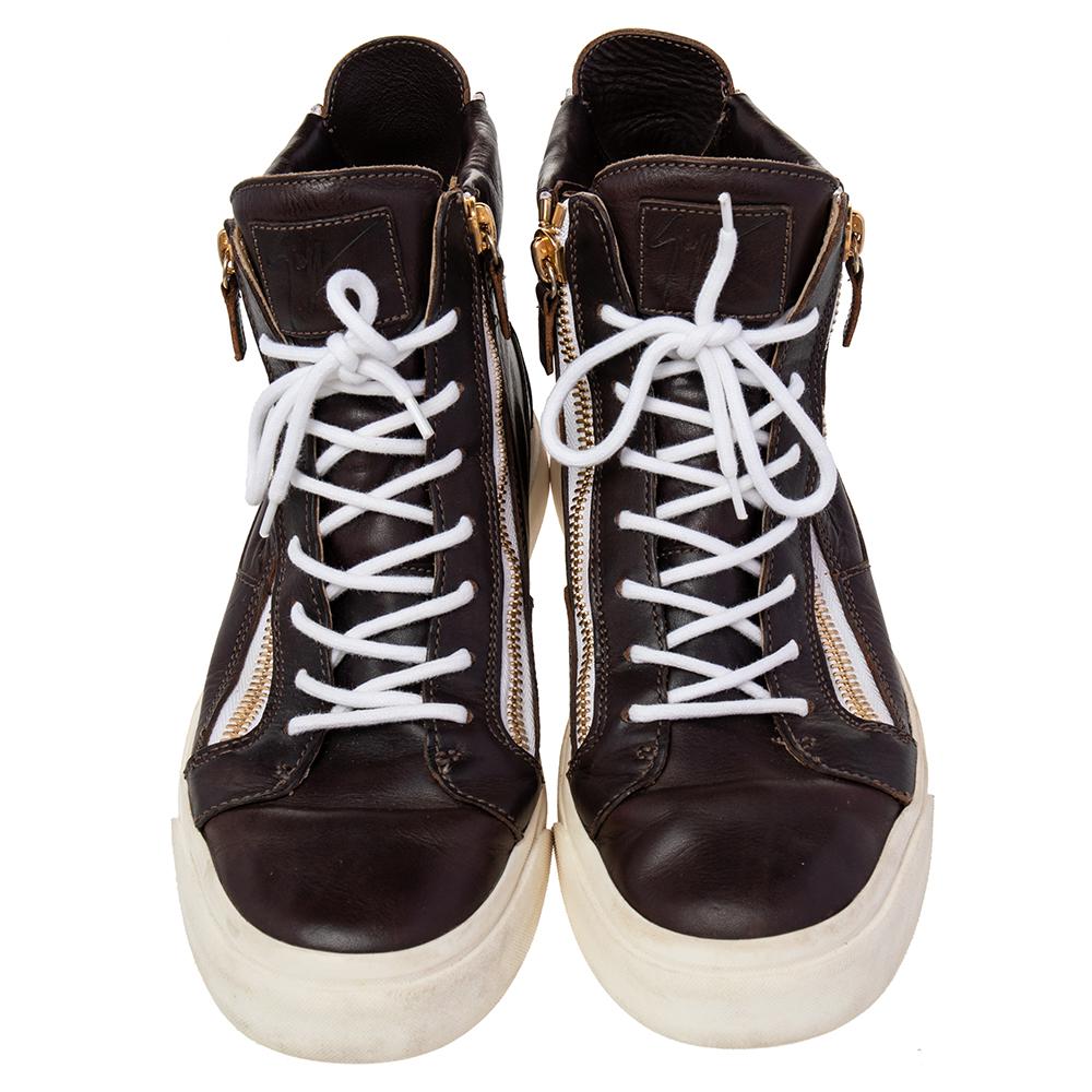 These Giuseppe Zanotti sneakers are meant to deliver a statement look. Crafted in Italy, they are made of brown leather and detailed with lace-up fronts, double zip detailing, brand detail on the tongue, leather lining, and white rubber