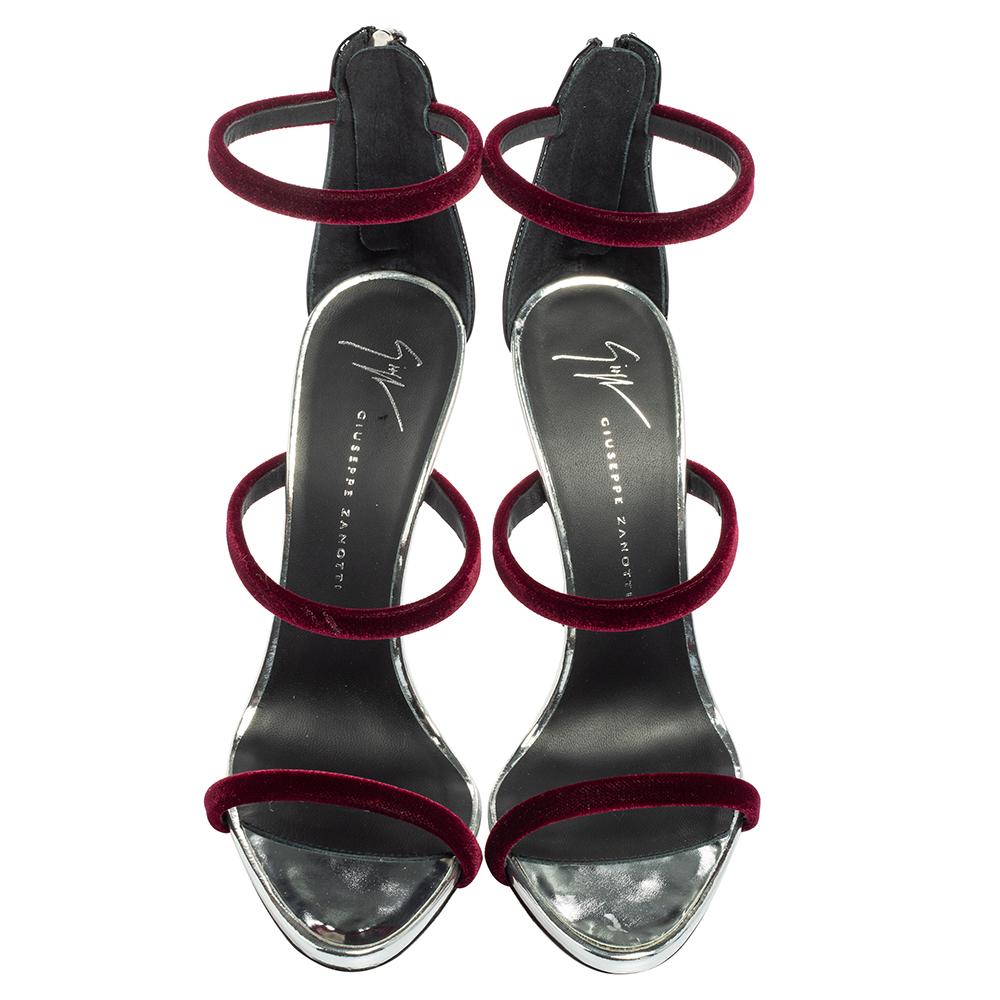 Merging elegant fashion and sensuous style, these burgundy-hued Giuseppe Zanotti Harmony sandals come crafted with patent leather and three velvet straps on each and fastened with zippers on the extended counters. They are visually stunning and they