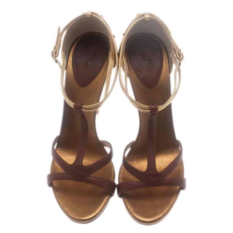 Add instant glam to any outfit with these beauties by Giuseppe Zanotti. Made from smooth leather, they have cognac and gold colored t-straps and buckle adjustable ankle straps. They feature rounded toes, gold-tone metal plates at their 12cm heels.

