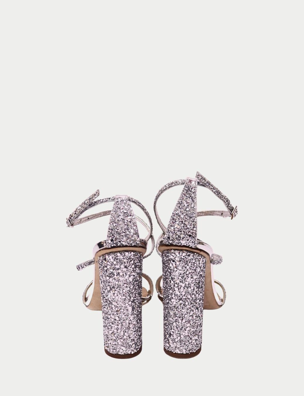Brilla con un glamour atrevido con estos tacones bloque de purpurina plateada de Giuseppe Zanotti, un par que combina el brillo de la alta costura con la artesanía italiana. Con un diseño de tiras y una hebilla segura en el tobillo, estas sandalias