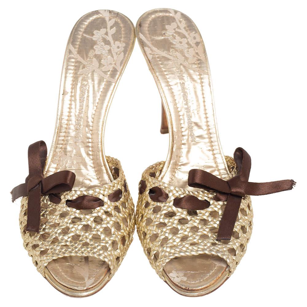 Diese Sandalen von Giuseppe Zanotti verleihen Ihrem Look im Handumdrehen Glamour. Ihr Äußeres besteht aus goldfarbenem, gewebtem Leder, das auf der Vorderseite mit einem kontrastierenden Schleifenmotiv verziert ist. Diese Gleitsandalen haben einen