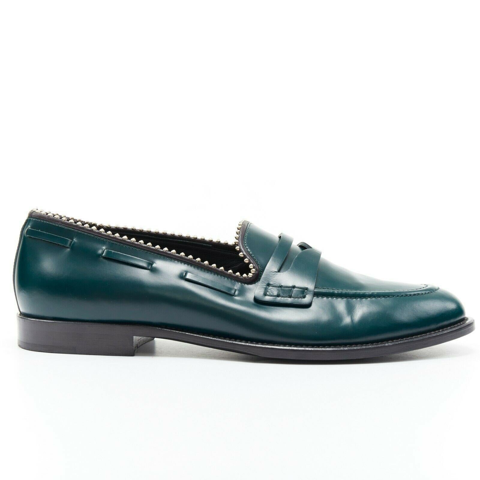GIUSEPPE ZANOTTI green leather silver stud trimmed penny loafer EU44

GIUSEPPE ZANOTTI
Dark green leather upper. Silver stud embellishment along opening trim. Cut out detail at front flap. Stitch detail along side. Tonal stitching. Stacked wooden