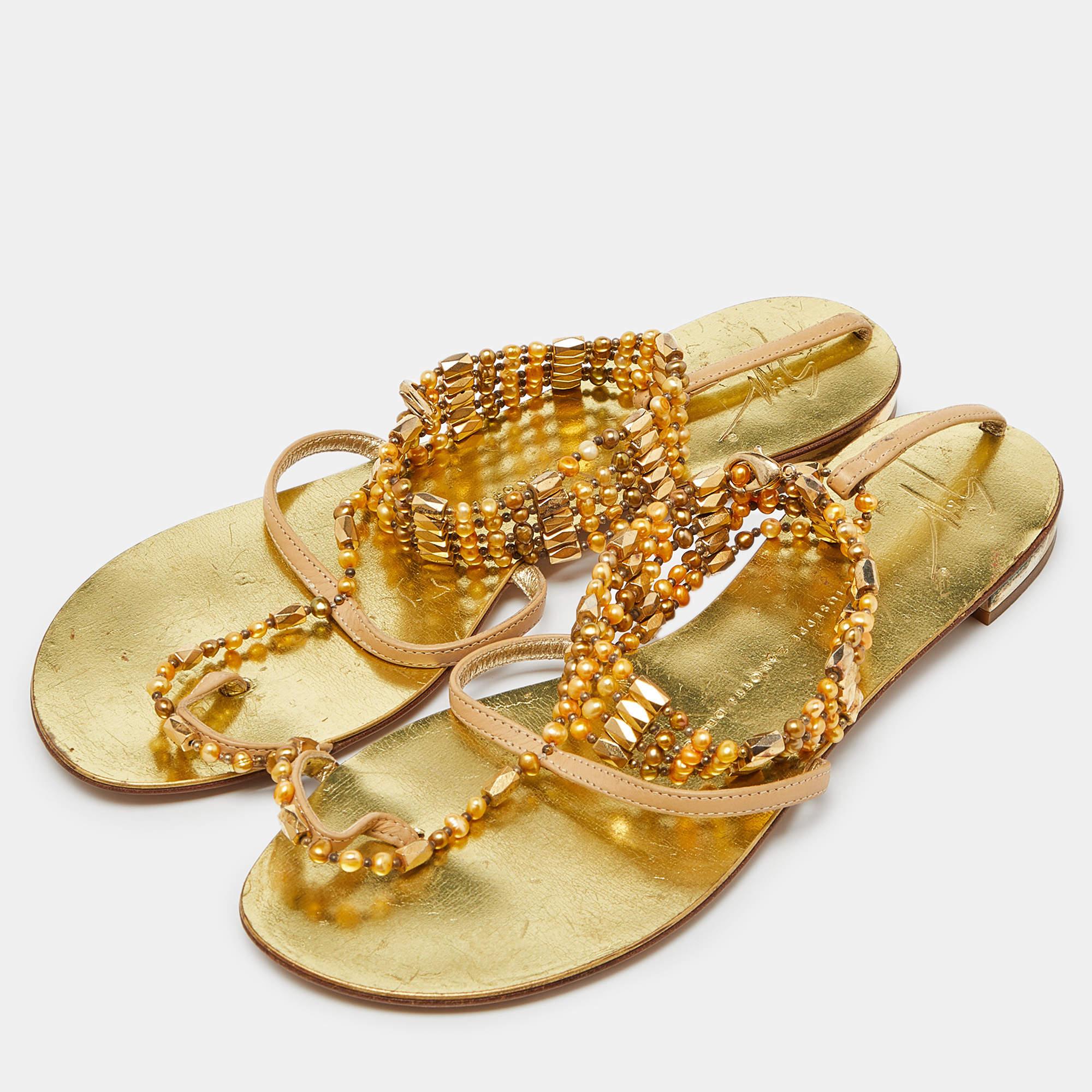 Elegance and poise take center stage in these stunning sandals from Giuseppe Zanotti. They have been crafted from beige leather in a thong design and beautifully styled with stone and crystal embellished straps. They are complete with comfortable