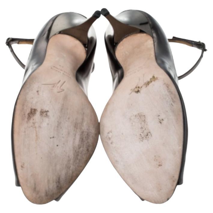 Eleganz und feminine Anmut zeichnen diese Pumps von Giuseppe Zanotti aus! Die metallisch grauen Schönheiten sind aus Leder gefertigt und haben eine Peep-Toe-Silhouette. Sie haben Schnallenriemen am Knöchel, eine bequeme ledergefütterte Innensohle