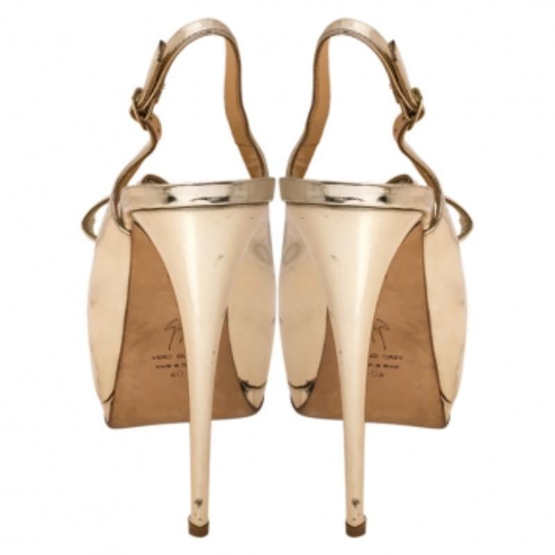 Estas sandalias de moda de Giuseppe Zanotti pueden dar un cambio de imagen a todo tu conjunto. Están confeccionados en piel dorada metalizada y diseñados con lazos y tirabuzones con cierre de hebilla. El par está colocado sobre tacones y plataformas