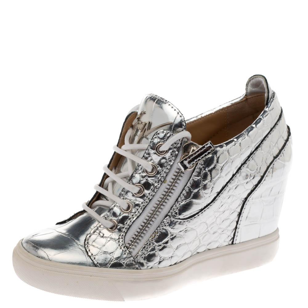 These sneakers by Giuseppe Zanotti are meant to be flaunted. Crafted from croc-embossed leather, they feature a gorgeous metallic silver exterior with double zipper details on sides and lace-ups. The pair is beautifully completed with wedges and