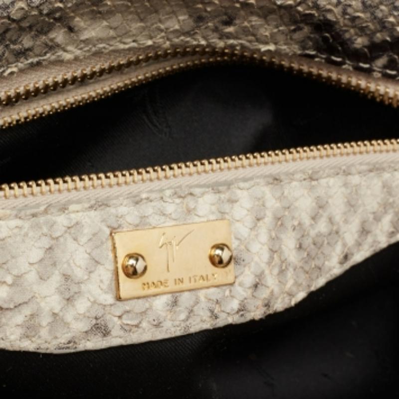 A striking piece from Giuseppe Zanotti to give you days of easy style! Crafted from python-embossed leather and decorated with the brand plaque on the front, the clutch has an undeniable charm of luxury. It is complete with patent leather trims and