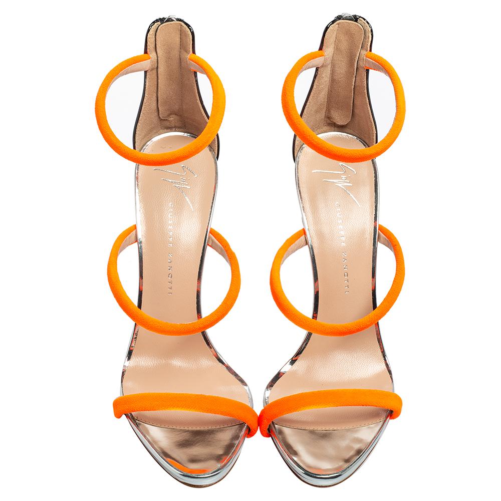 Merging elegant fashion and sensuous style, these neon orange-hued Giuseppe Zanotti Harmony sandals come crafted with patent leather and three velvet straps on each and fastened with zippers on the extended counters. They are visually stunning and