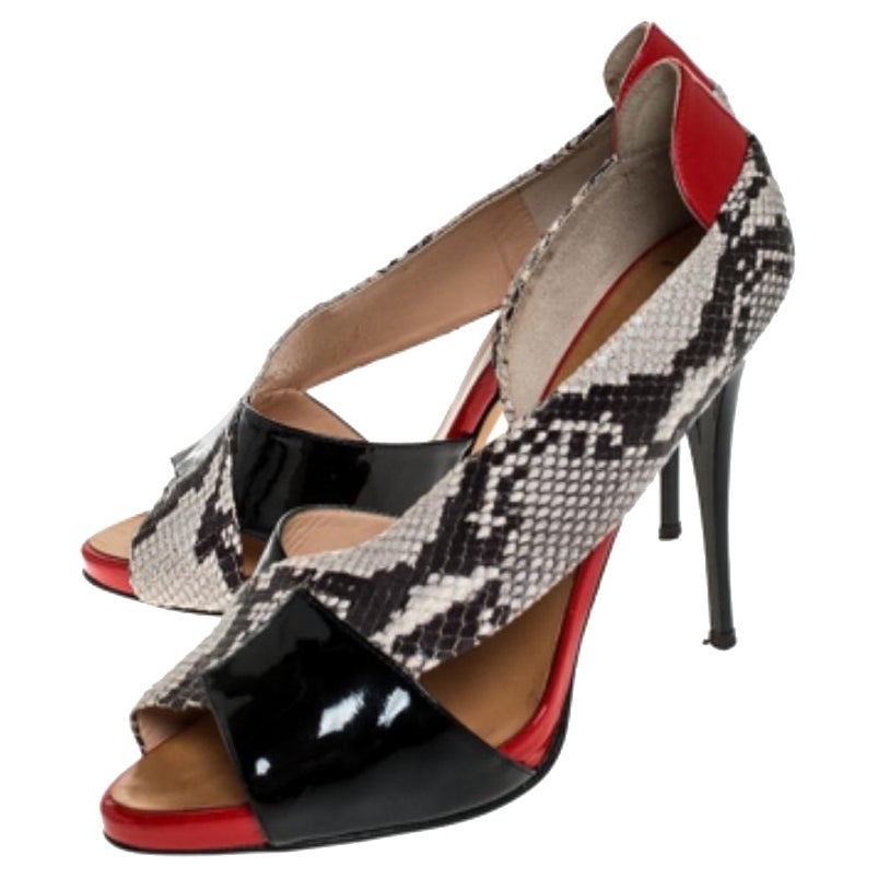 When it comes to high-fashion shoe designs, Giuseppe Zanotti tops our list! These sandals are crafted from patent leather and python-embossed leather into an elegant silhouette. They flaunt open toes and 12 cm high heels. They are complete with