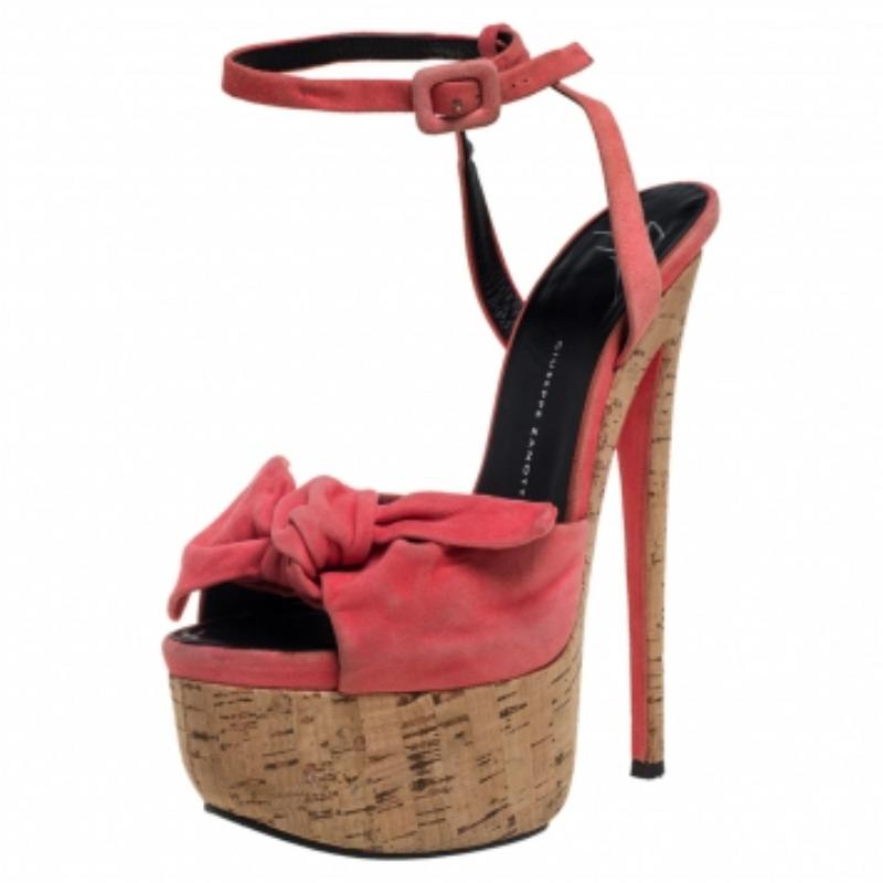 Crafted in pink suede, these Giuseppe Zanotti sandals feature a beautiful bow at the vamps. They come with open toes and wrap-around ankle straps with side buckle fastenings. The high cork platforms with 16 cm heels add to the gorgeous design.