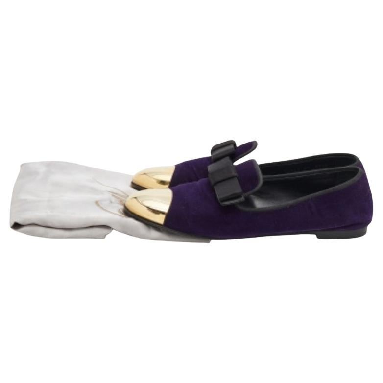 Das Design dieser Giuseppe Zanotti Slipper wird durch die goldfarbene CAP-Zehe auf der lila Außenseite hervorgehoben. Sie sind aus Samt gefertigt, mit einer Schleife auf dem Obermaterial verziert und bequem zum Hineinschlüpfen.