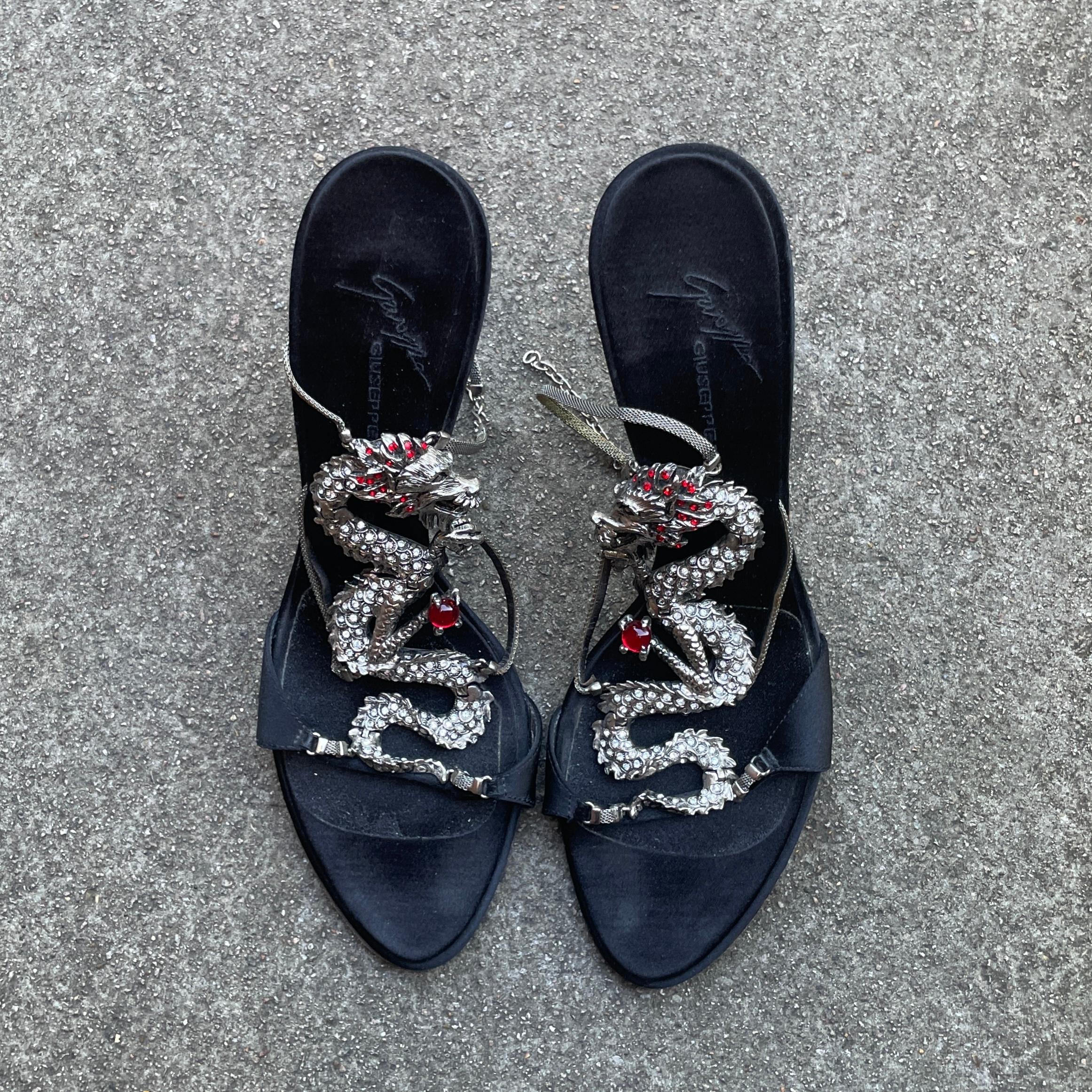 Interdite Vintage presenta un par de tacones Giuseppe Zanotti S/S 2004 Dragón de satén negro

- Giuseppe Zanotti

- De la colección Primavera / Verano 2004

- Tacones Madre Dragón con adornos de dragón de metal plateado con incrustaciones de strass