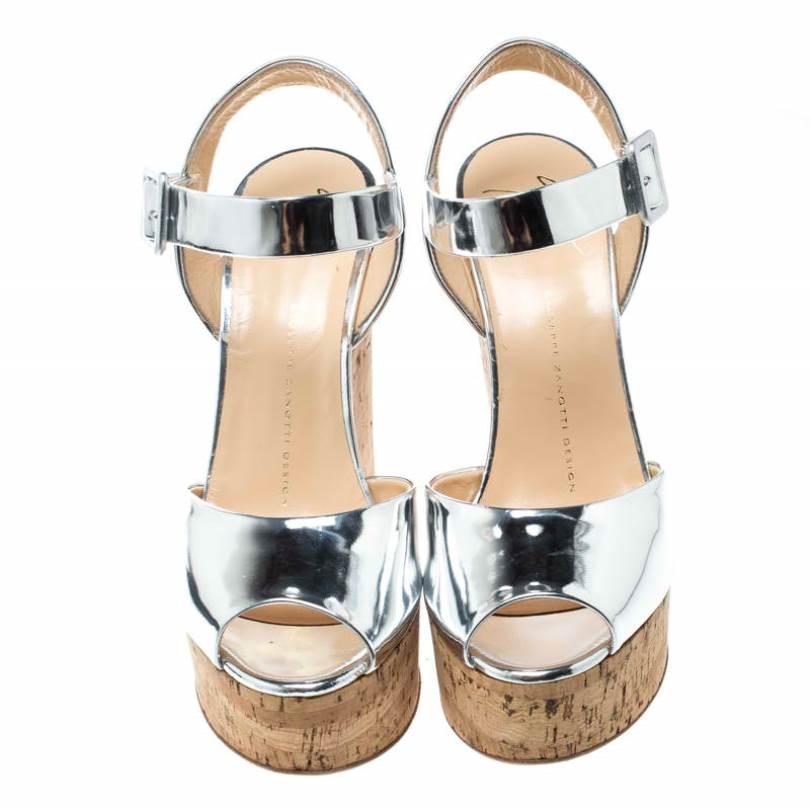 These Giuseppe Zanotti sandals exude charm with their glossy silver leather panels at the front and ankle straps secured by buckles. They feature cork wedges that make them comfortable to be worn all day long.

Includes: The Luxury Closet Packaging

