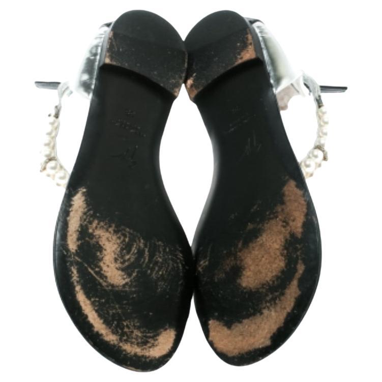 Komfort gepaart mit Mode wirkt Wunder und diese Sandalen von Giuseppe Zanotti sind ein wahres Beispiel dafür. Diese silbernen Sandalen sind aus Lackleder gefertigt und mit einem Zehenring versehen. Sie sind mit exquisiten Perlen an den Knöchelriemen