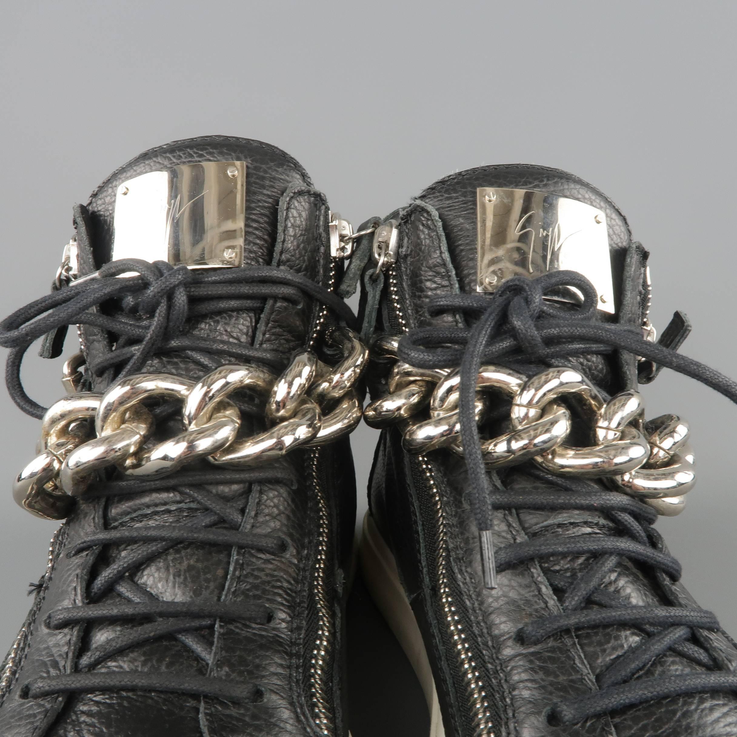 GIUSEPPE ZANOTTI HOMME high top sneakers come in black textured leather and feature a lace up front, embossed logo plaque tongue, double side zip, white rubber sole, zip heel detail, and oversized silver tone metal chain bangle ankle strap with