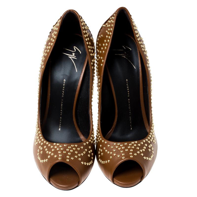 Exuding elegance, these Giuseppe Zanotti pumps are exceptional in design and appeal. Crafted in tan leather, the peep-toe pumps are studded with gold-tone rivets. They are elevated on 12 cm heels.

Includes: Price Tag, Original Box

