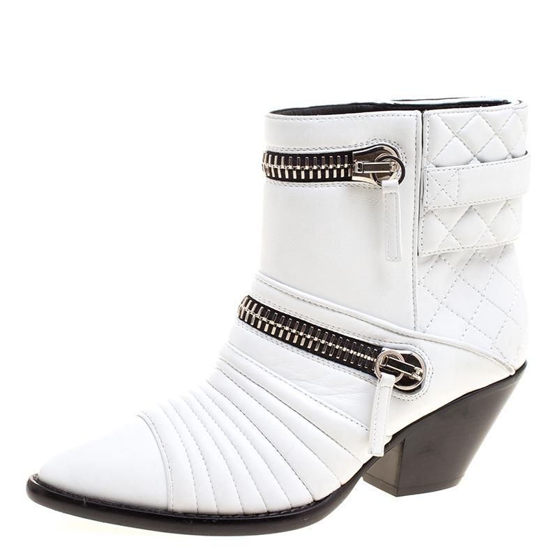 Crafted out of a bright and glamourous white leather, these boots display a quilted design on the body that is embellished with faux zippers in gold-tone. The heel is elevated slightly on a block heel. These boots are versatile with any kind of