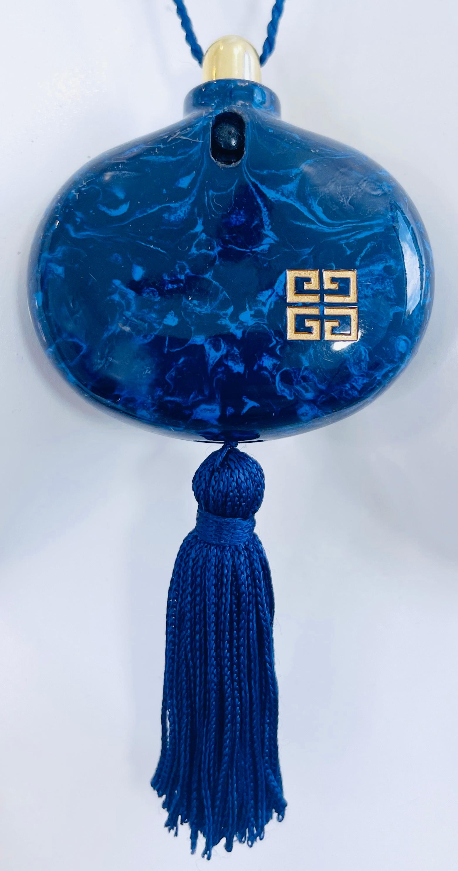 Magnifique collier pour flacon de parfum Givenchy de la fin des années 70, bleu marine marbré et doré. Logo Givenchy doré dans le coin inférieur gauche. Gland attaché à la base. Il n'y a plus de parfum dans le flacon et il ne reste plus d'odeur.