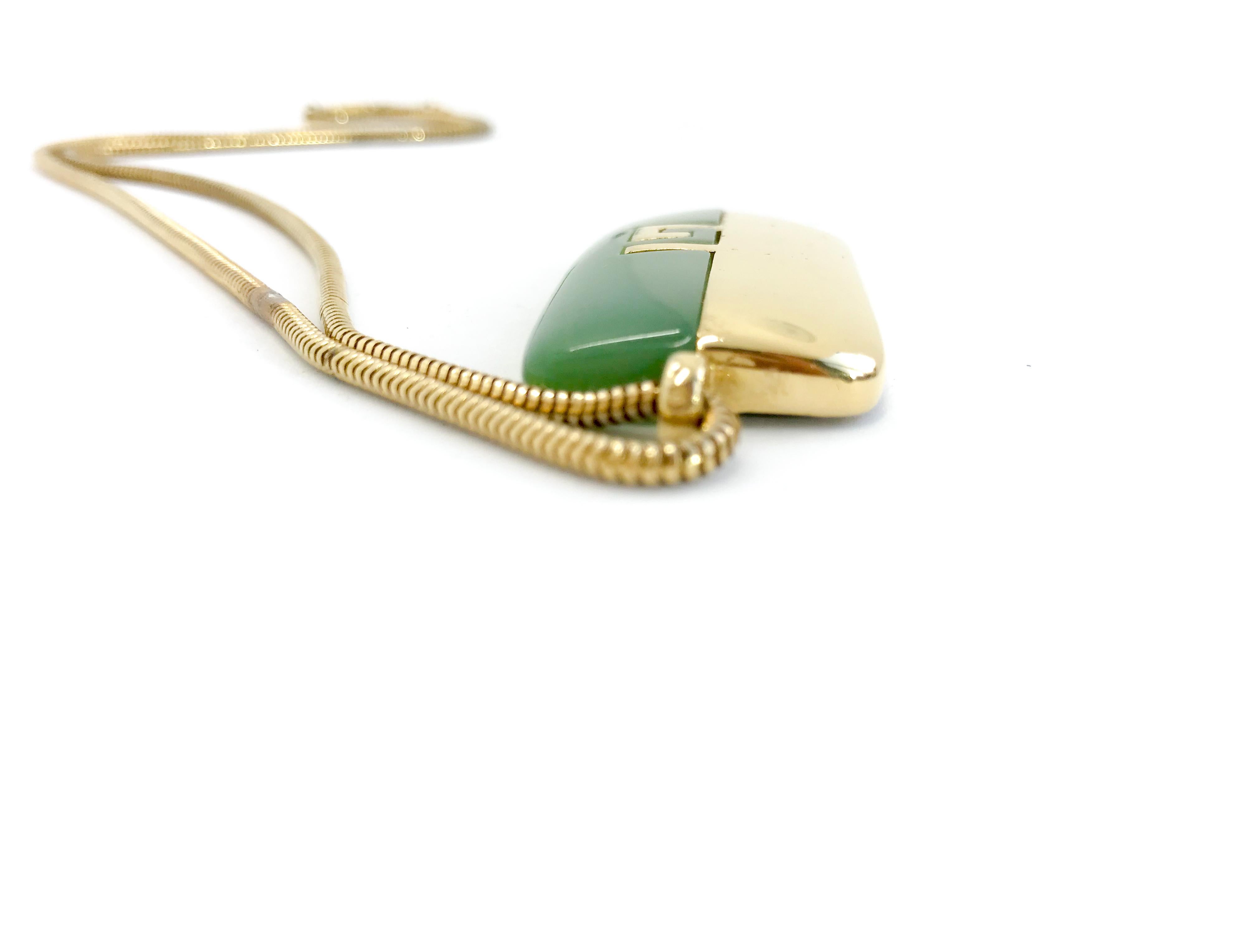 Givenchy 70s Vintage Faux Jade and Gold Pendant Necklace on Snake Chain.

Signed Givenchy on reverse of pendant and on chain with G logo closure.  

23 inches gold tone snake chain has the fold over clasp with two signature G's. 

Pendant measures 2