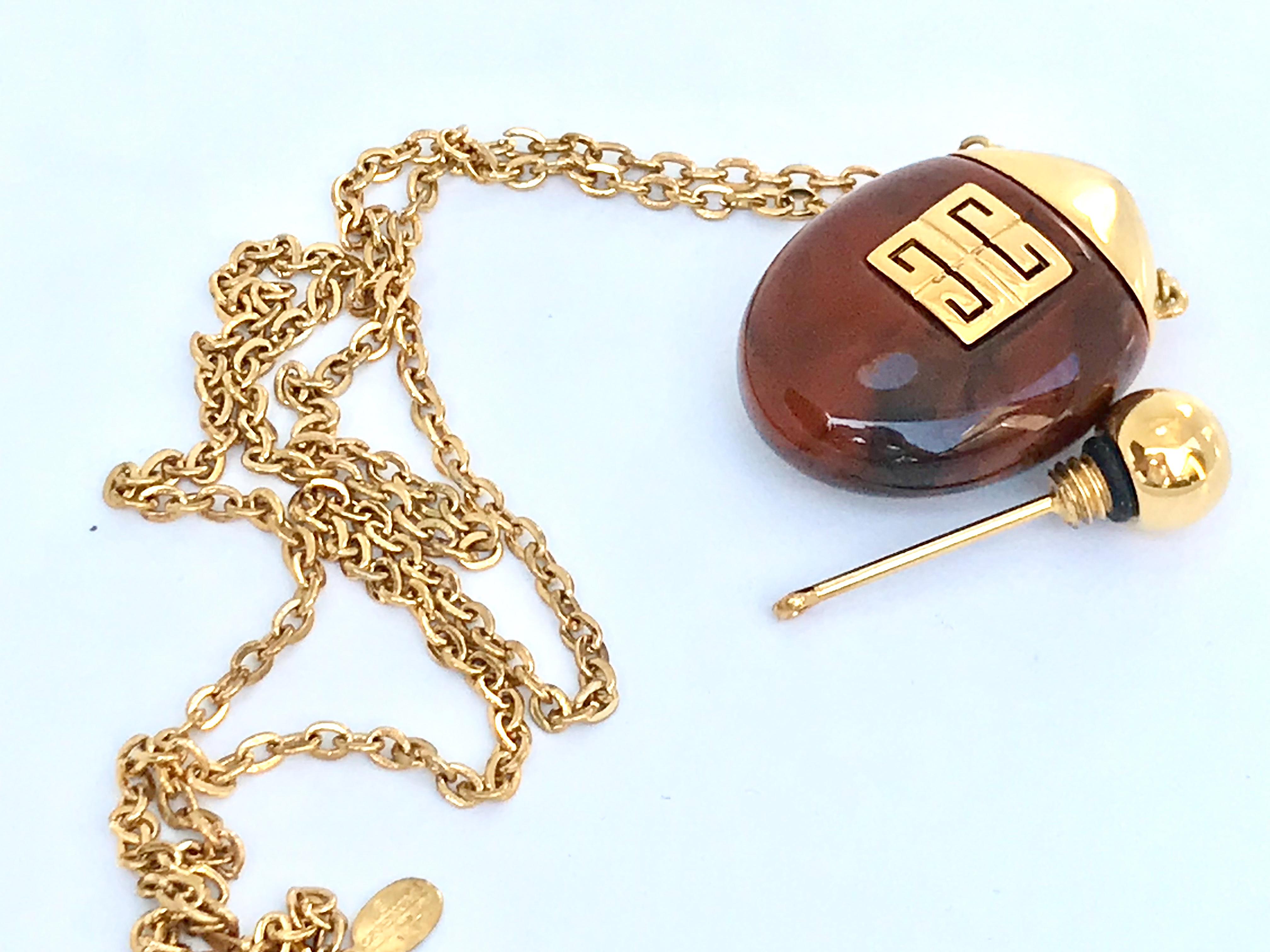 Givenchy 1970s Vintage Perfume Bottle Necklace Pendant

Givenchy 1977 vintage faux tortoiseshell gold plated perfume bottle pendant. Signed and dated on the hangtag.  Can be used for your own favourite perfume on a night out. Top screws off to