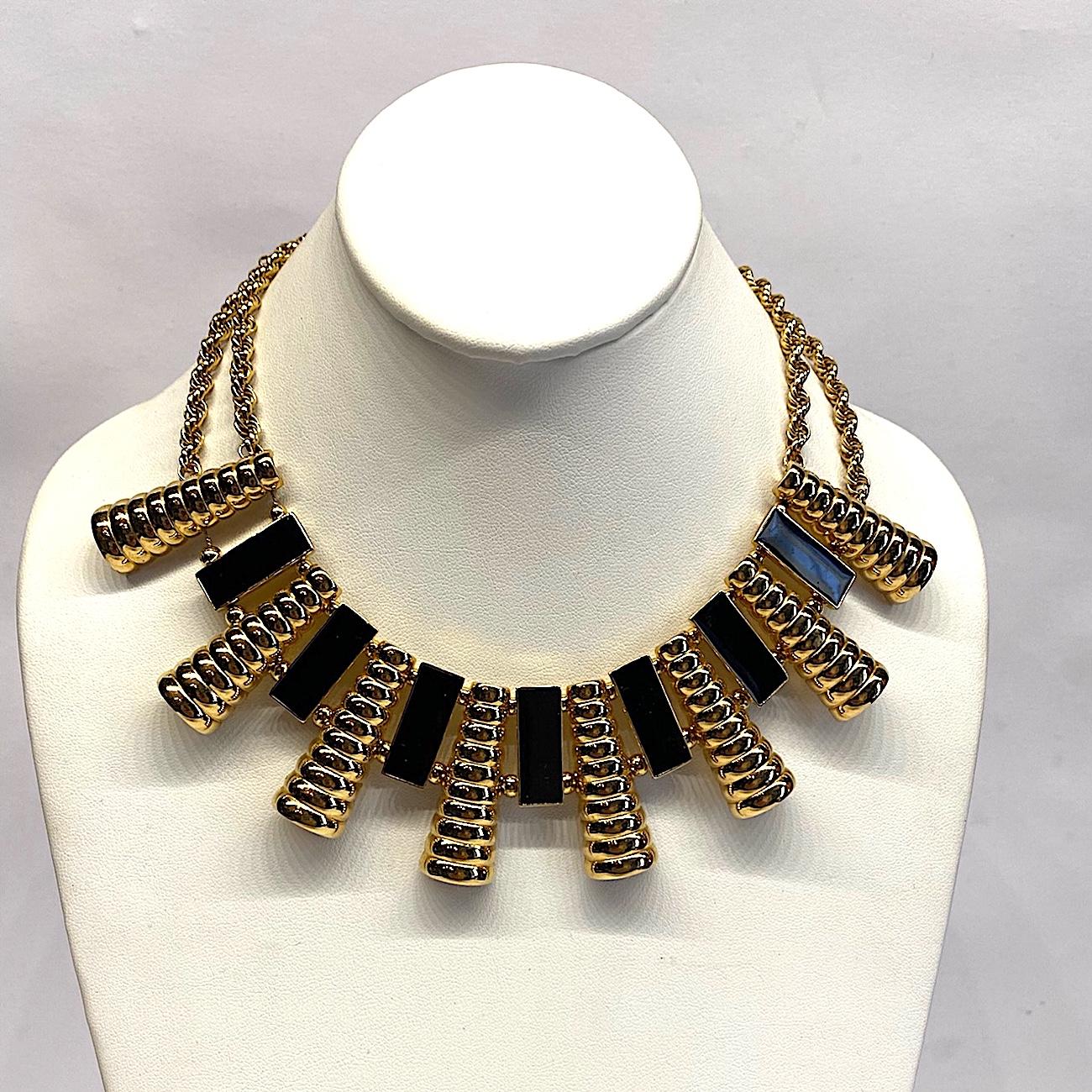 A tailored Art Deco revival necklace by Givenchy from the 1980s. The front bib piece is a combination of long curved and ribbed links alternating with rectangular links with black enamel centers. They are strung on chain with small bead spacer