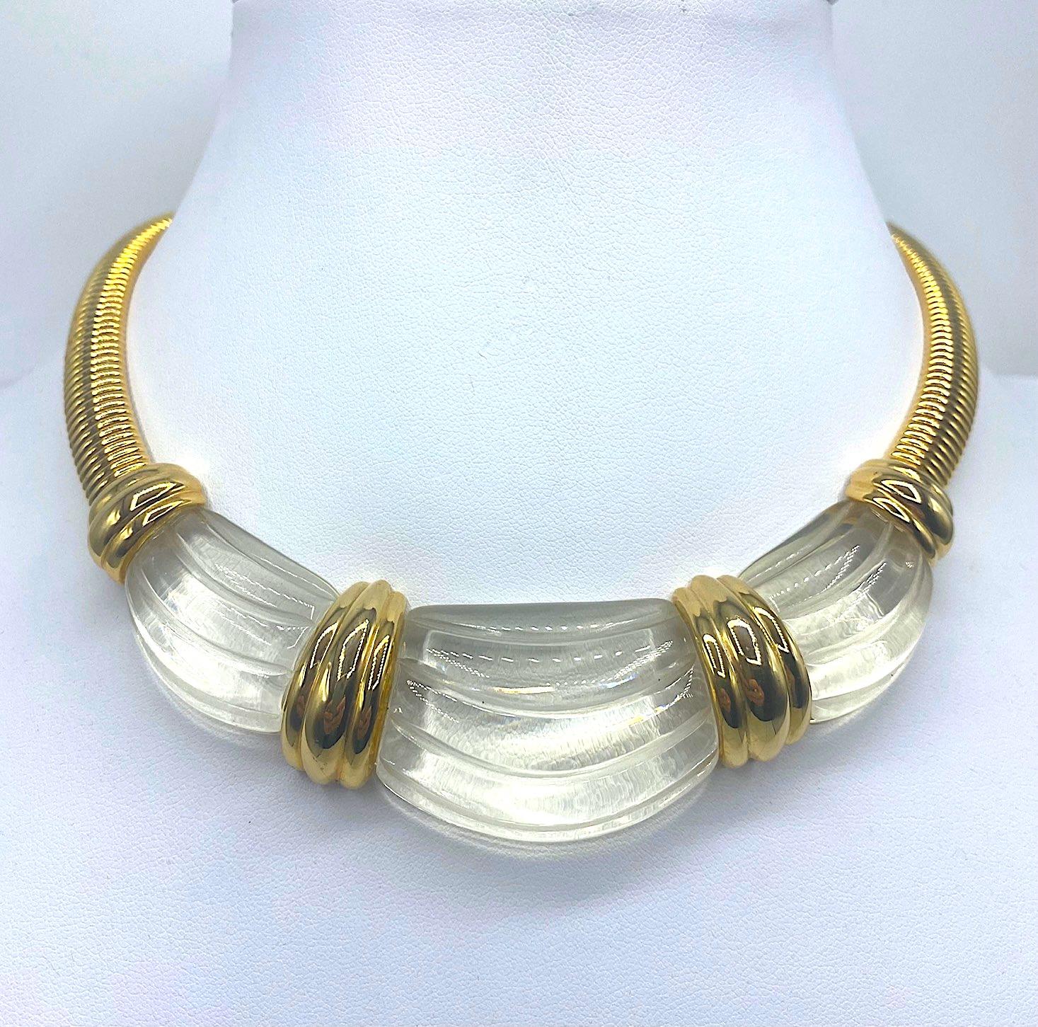 Elegant 1980s fashion necklace from Parisian fashion house Givenchy. The omega link necklace is richly gold plated and set with a molded swag clear lucite center piece in faux carved rock crystal. The necklace is 16 inches long with a 1.25 inch drop