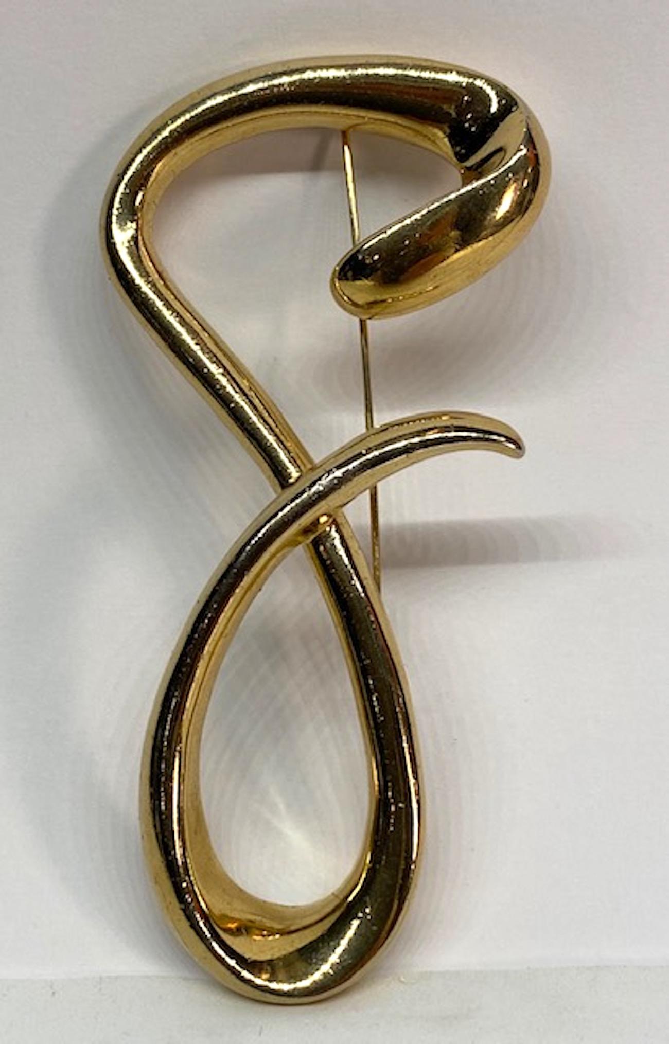 A chic 1980s freeform script letter G brooch by Givenchy. The large gold plate brooch measures 2.25 inches at the widest and 4.38 inches tall. The brooch is very three dimensional with the tale of the G overlapping the back part. It is .5 of an inch