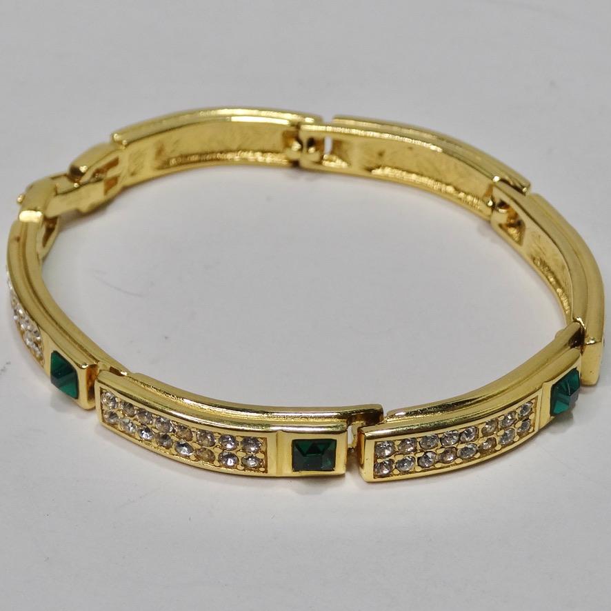 Timeless and regal 1990 18K gold plated bracelet! Stunning yellow gold is contrasted by an array of silver circular rhinestones and synthetic emeralds. Featuring a Givenchy logo at the center and Givenchy engravings on the inside. This is such a
