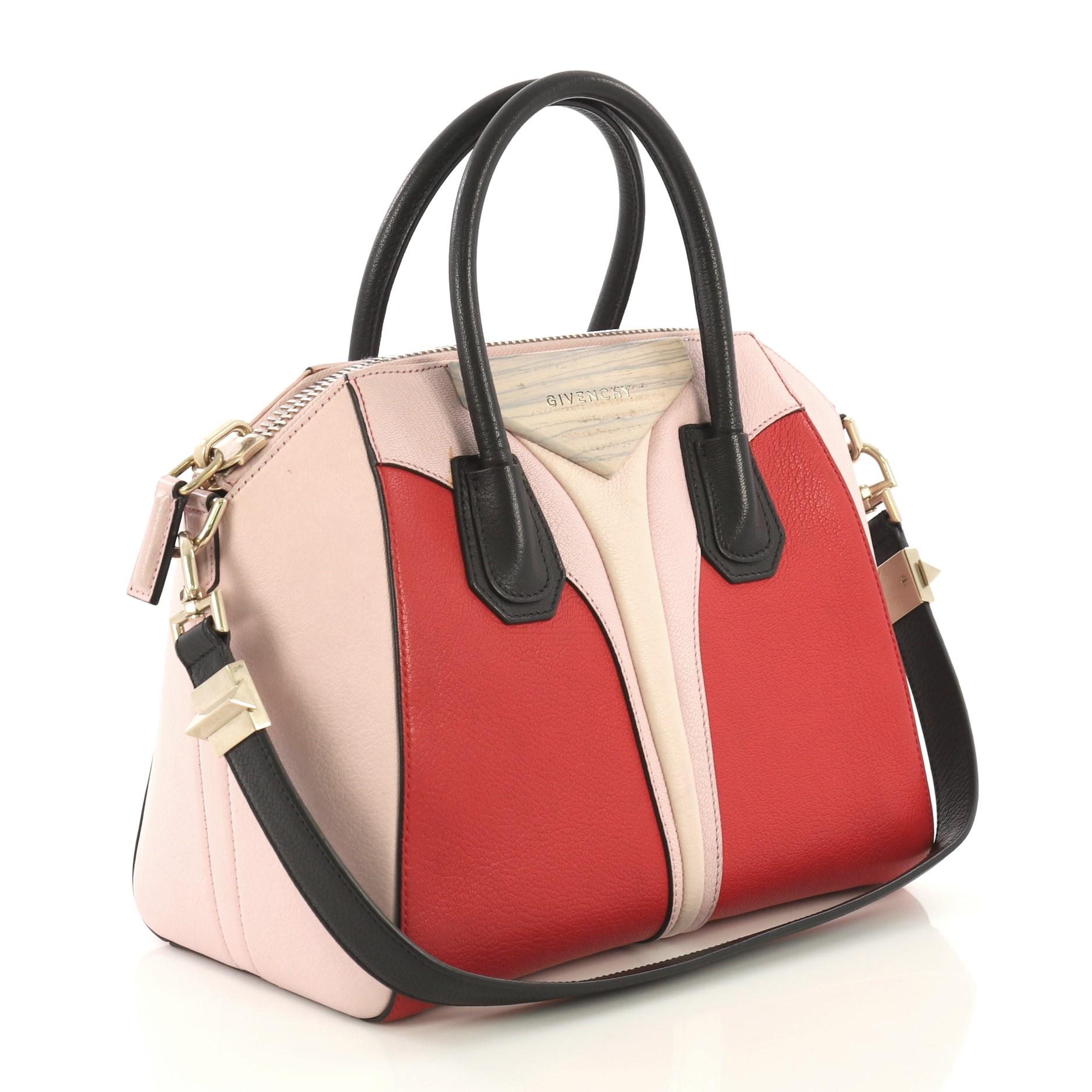This Givenchy Antigona Architect Bag Colorblock Leather Small, crafted in red and pink leather, features dual rolled leather handles, envelope fold with raised logo, and gold and silver-tone hardware. Its zip closure opens to a black fabric interior