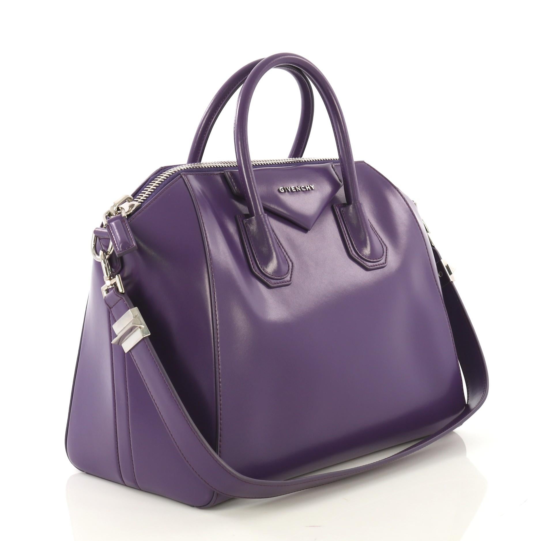 This Givenchy Antigona Bag Glazed Leather Medium, crafted from purple glazed leather, features dual rolled leather handles and silver-tone hardware. Its zip closure opens to a beige fabric interior with zip and slip pockets. .

Estimated Retail