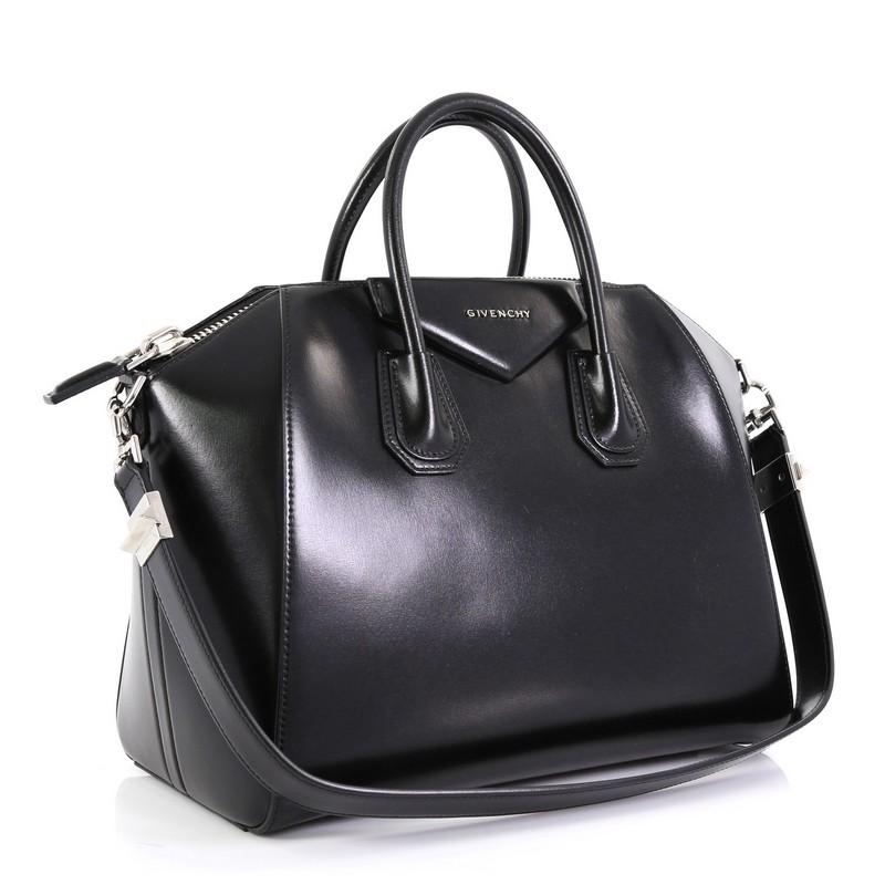 This Givenchy Antigona Bag Glazed Leather Medium, crafted from black glazed leather, features dual rolled leather handles and silver-tone hardware. Its zip closure opens to a black fabric interior with zip and slip pockets.

Estimated Retail Price: