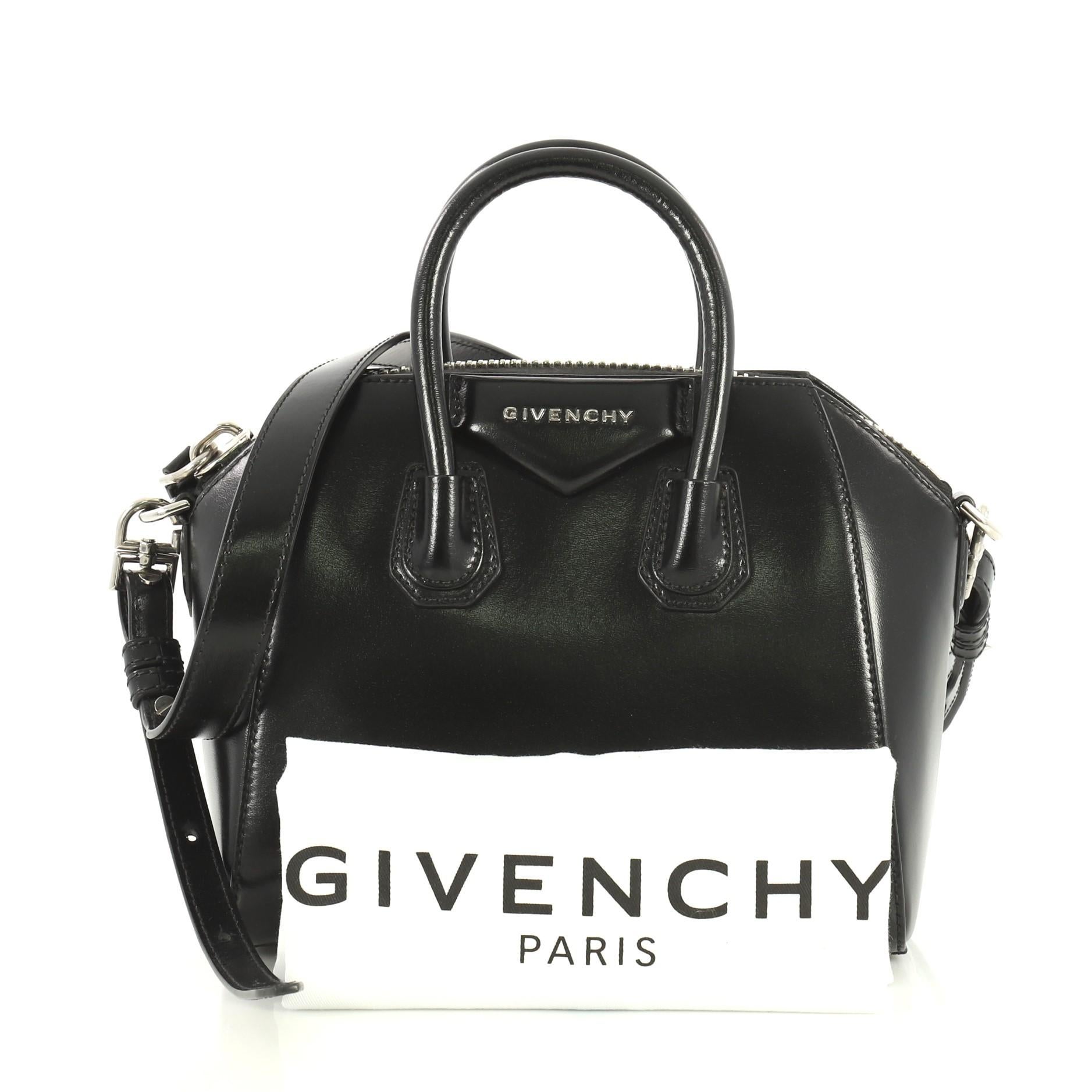 This Givenchy Antigona Bag Glazed Leather Mini, crafted from black glazed leather, features dual rolled leather handles and silver-tone hardware. Its zip closure opens to a black fabric interior with zip and slip pockets. 

Estimated Retail Price:
