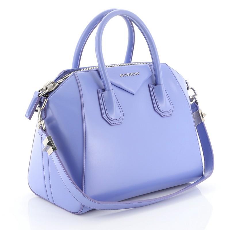 This Givenchy Antigona Bag Glazed Leather Small, crafted from purple glazed leather, features dual rolled leather handles and silver-tone hardware. Its zip closure opens to a neutral fabric interior with zip and slip pockets. 

Estimated Retail